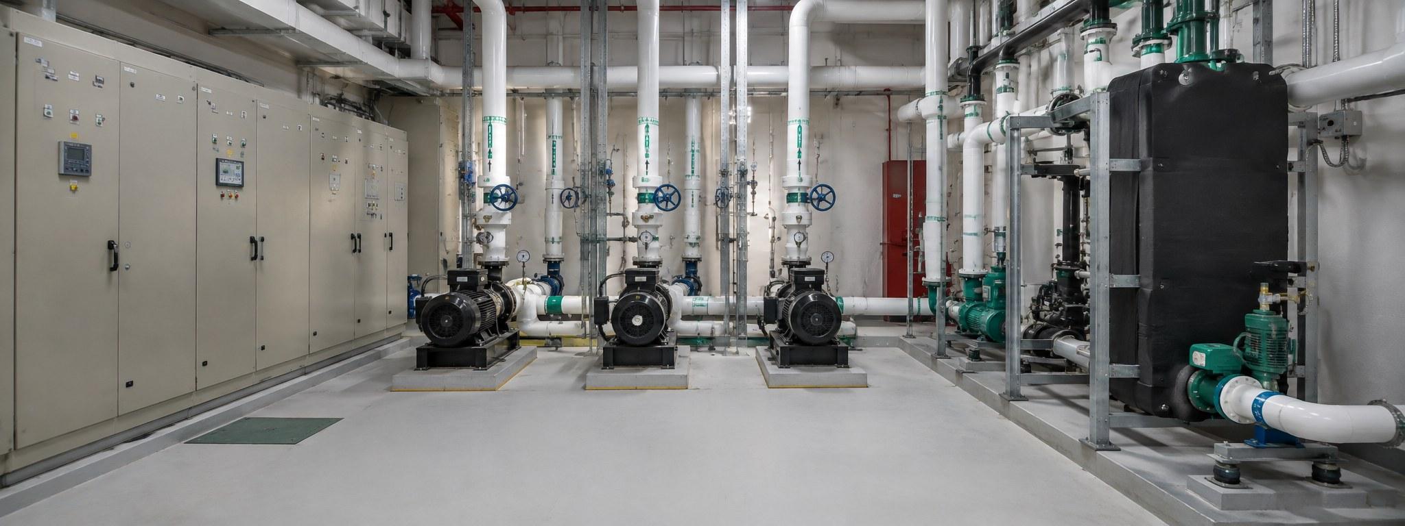 A plant room in a residential tower: pumps, valves, pipework and control panels